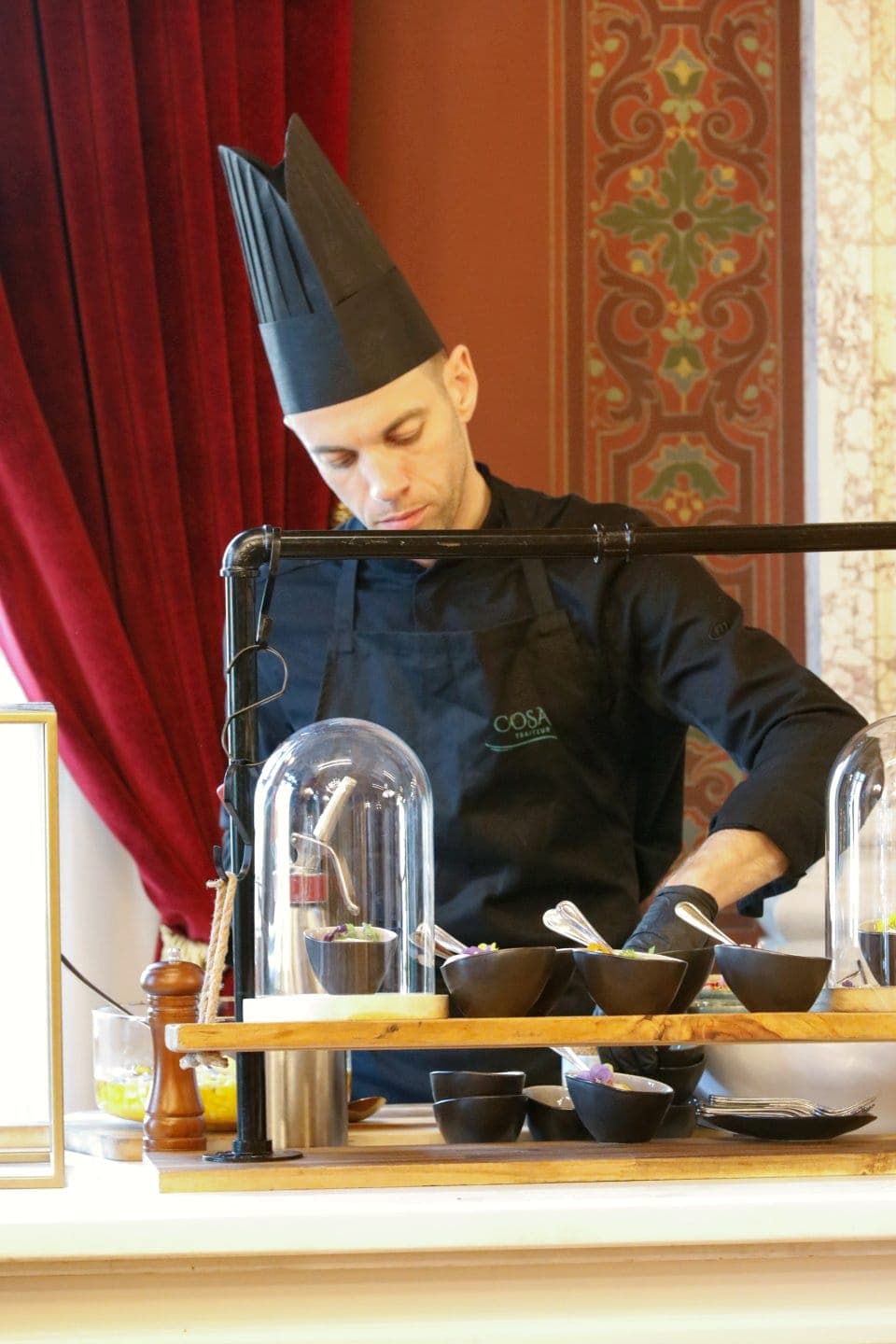 Chef assurant un service sous cloche pendant une réception