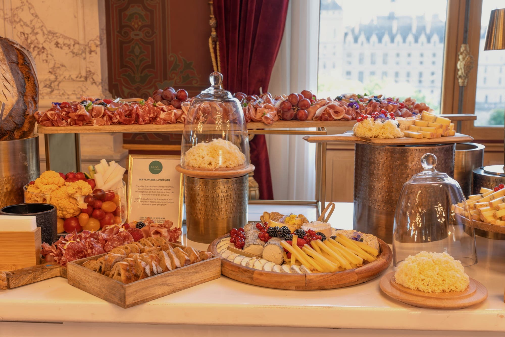 Buffet de fromages et charcuteries dressé face à la fenêtre