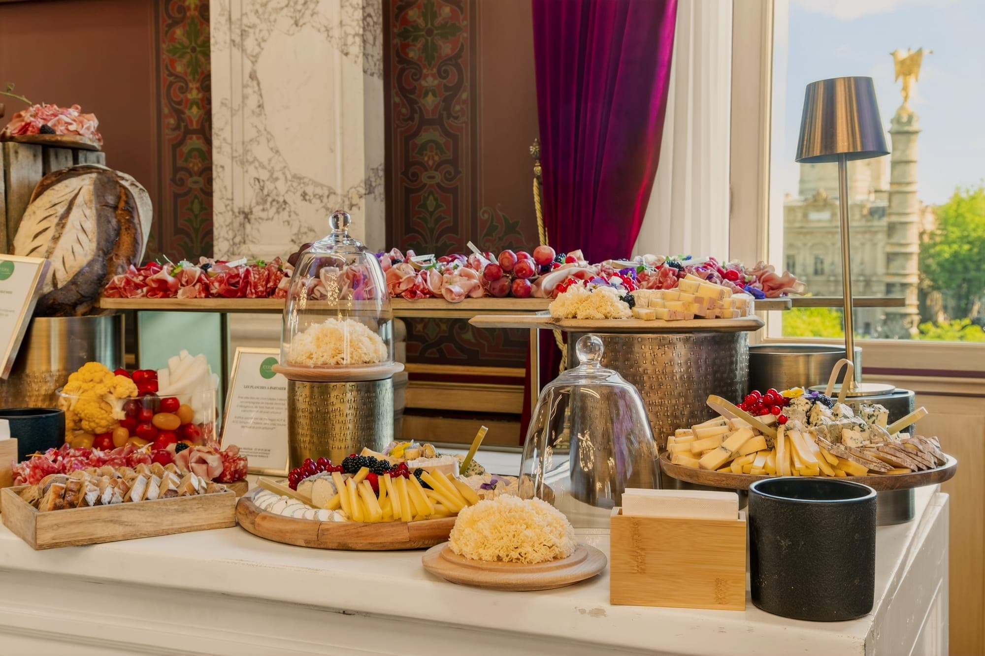 Buffet d'accueil dressé face aux fenêtres d'un salon d'honneur