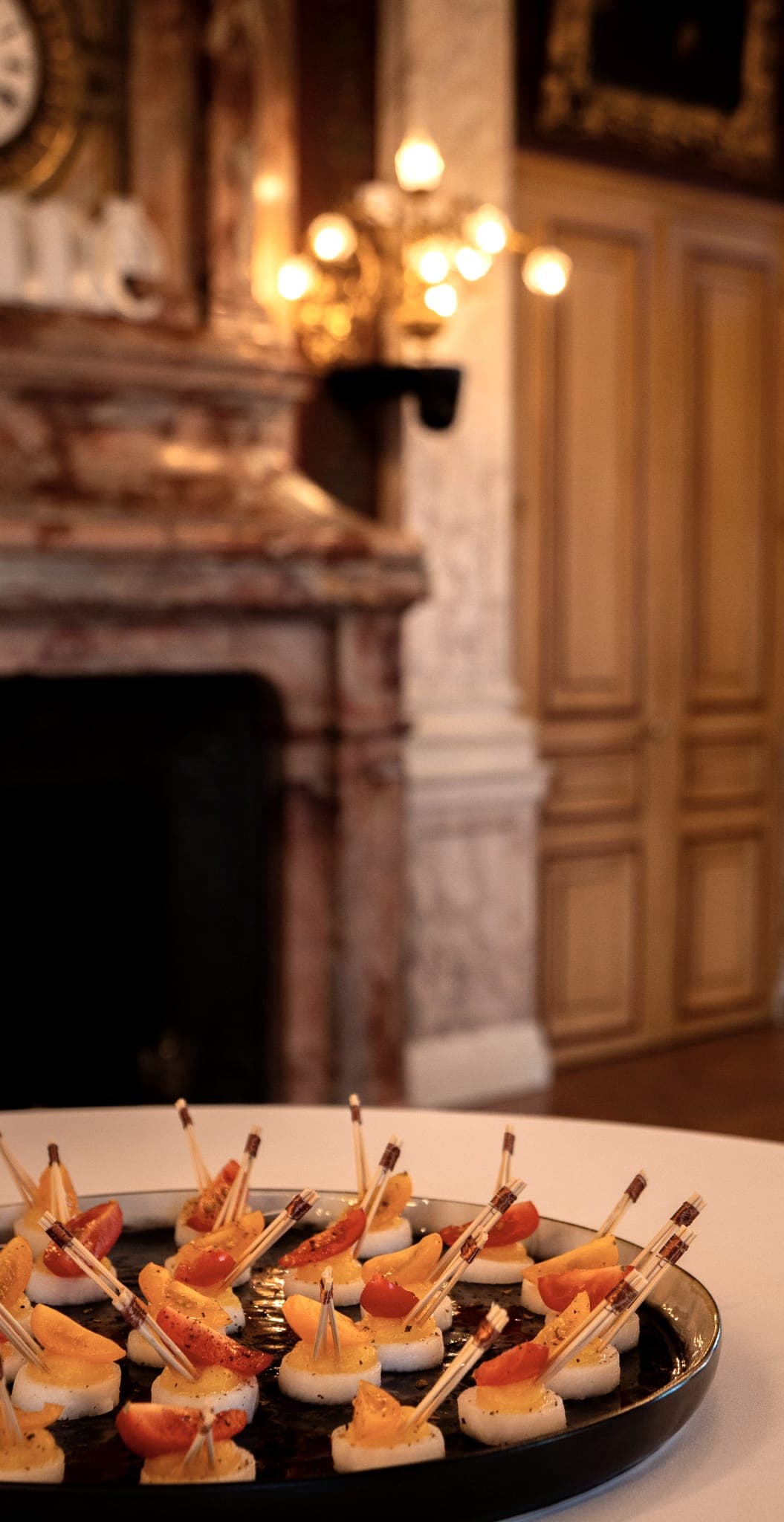 Plateau de pièces posé devant une cheminée de marbre