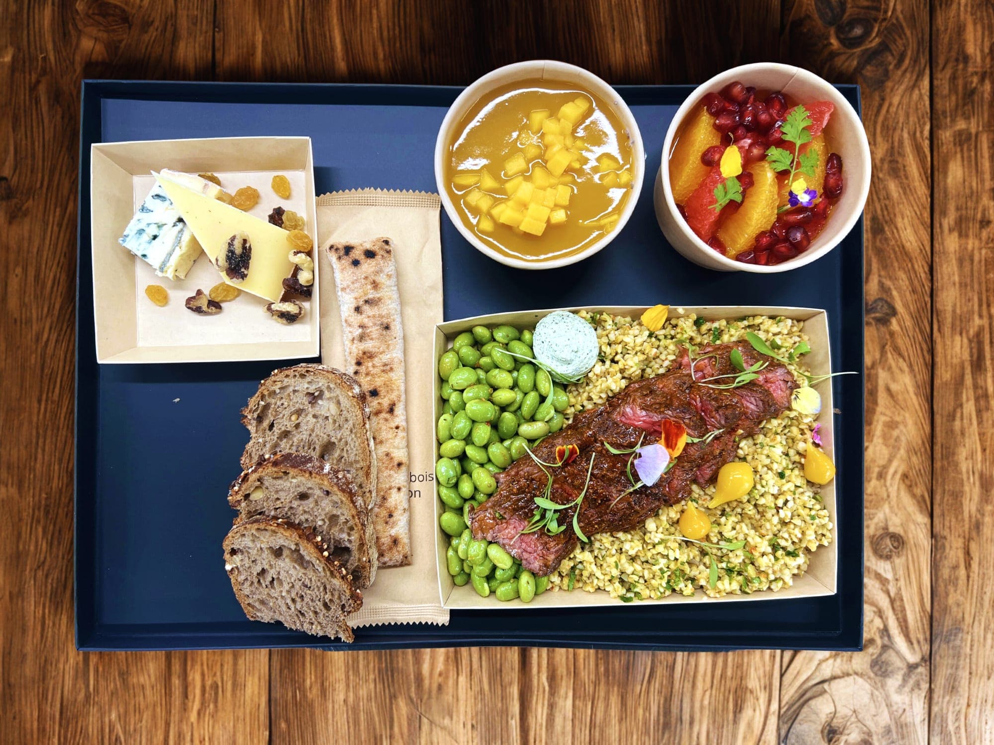 Plateau-repas dressé sur plateau bleu, pain et fromages