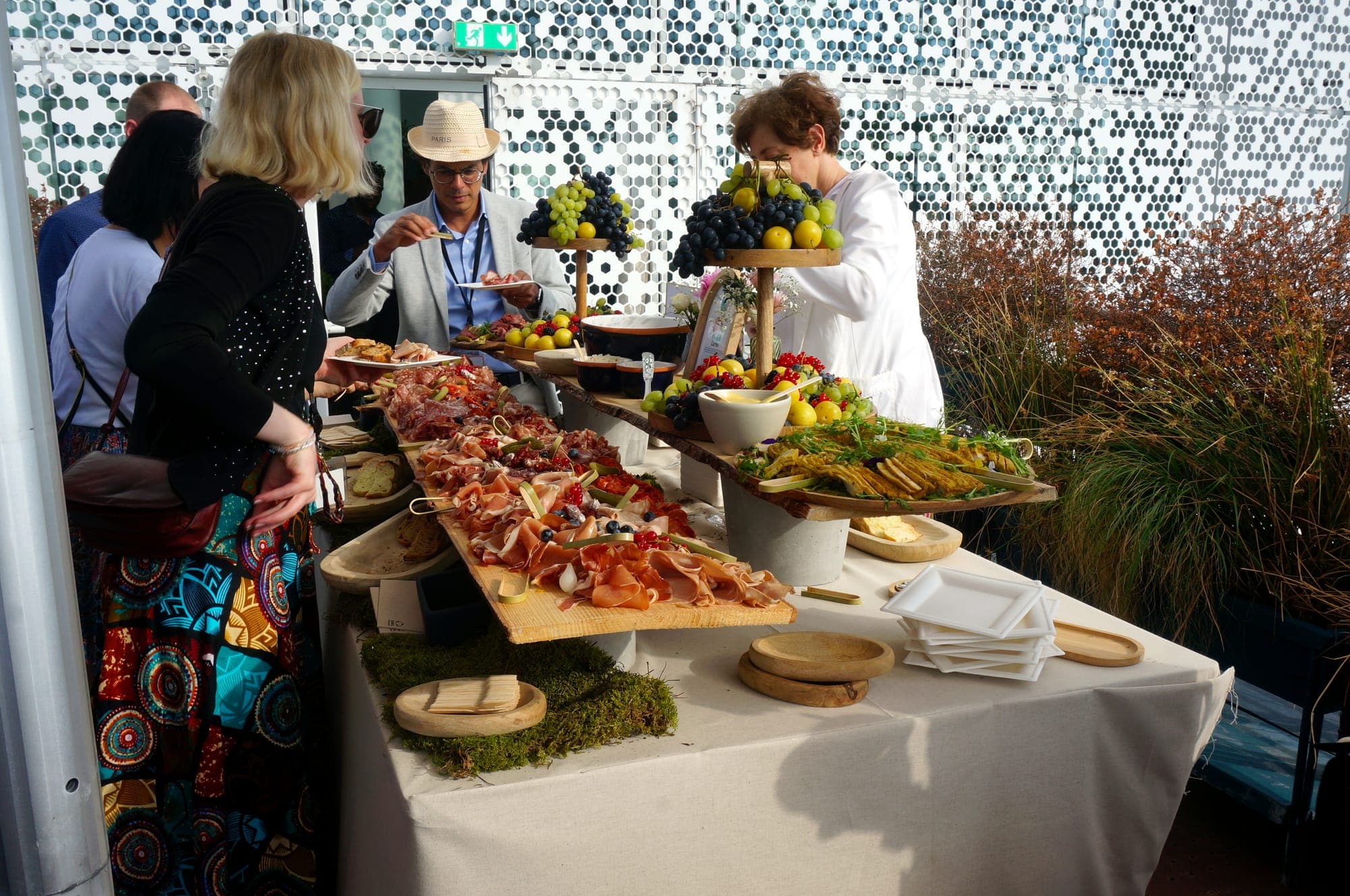 Buffet de séminaire dressé en terrasse, invités au service