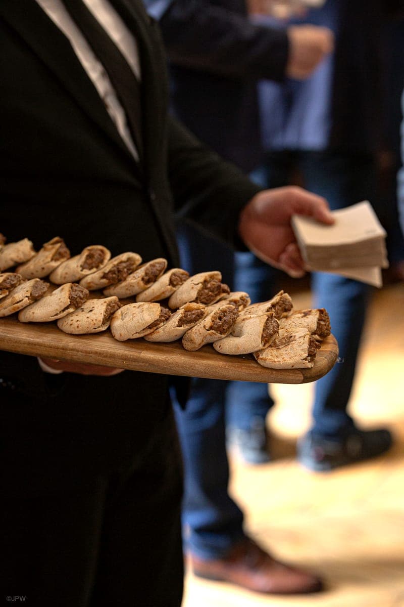 Canapés présentés sur planche par un membre de la brigade